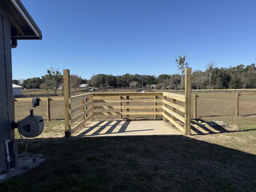 wooden farm gate attached to 4 board fence on residential acreage